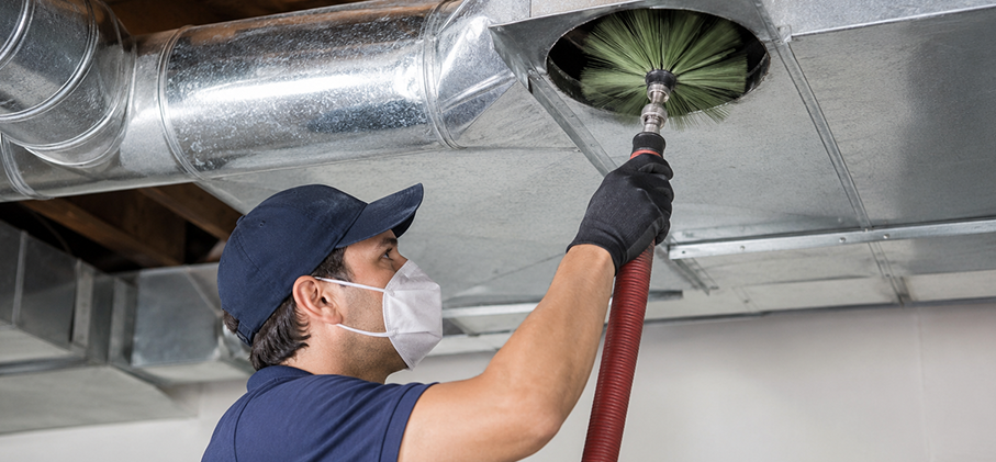 Technician cleaning HVAC return ducts with professional equipment.